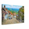 Painterly 1970s view of Gold Hill in Shaftesbury, Dorset, with cobbled street, cottages, stone walls, flowers, thatched roof and countryside beyond.