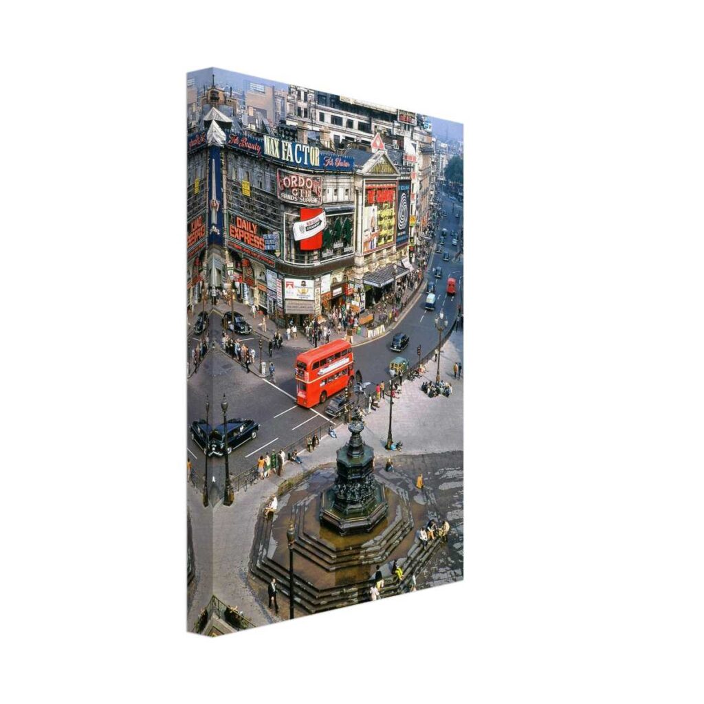 Photographic 1960s view of Piccadilly Circus in London with the Shaftesbury Memorial Fountain, red double-decker bus, crowds, vintage cars and The Graduate advertised at the London Pavilion.