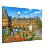 1960s view of the Station Hotel overlooking Ayr railway station in Ayr, Scotland, with its Victorian sandstone architecture, gardens and classic British cars, reimagined in a painterly style from a genuine vintage color photograph.
